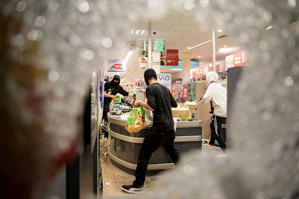 Protesters against the G20 Summit plunder and destroy a Rewe supermarket in Hamburg, Germany.