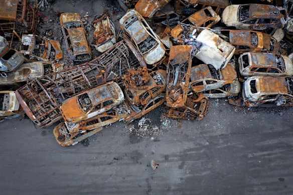 An aerial view of a man (at base) as he looks at vehicles destroyed by the war in Irpin.
