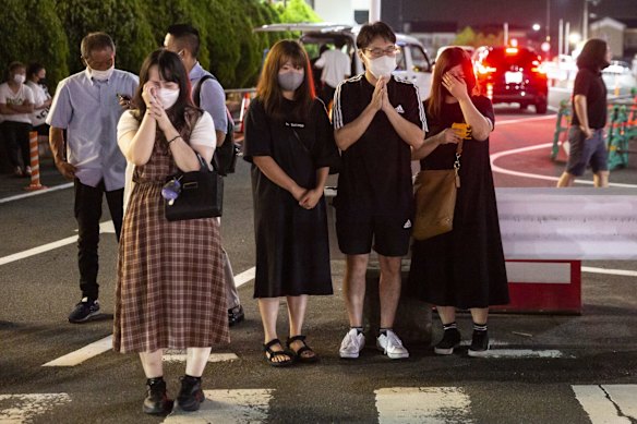 People pray and cry outside Yamato-Saidaiji Station.