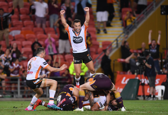 Bronco buster: Luke Brooks jumps for joy as Michael Chee Kam scores his match-winning try.