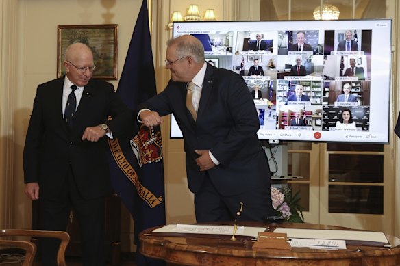 Governor-General David Hurley and Prime Minister Scott Morrison elbow and pose for photos with new appointments in the Morrison ministry, during a virtual swearing-in ceremony at Government House after a reshuffle of the Morrison ministry, in Canberra on Tuesday.