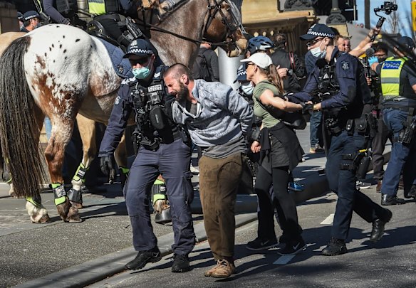 Police detain protesters on Spring Street during anti-lockdown rally in Melbourne.