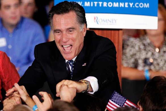 U.S. Republican presidential candidate Mitt Romney shakes hands with supporters.