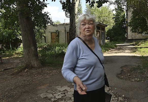 A woman stands outside her apartment building during four incoming artillery rounds in Lysychansk, a city under constant artillery fire from the Russian military and without water and power. Lysychansk, Ukraine. 