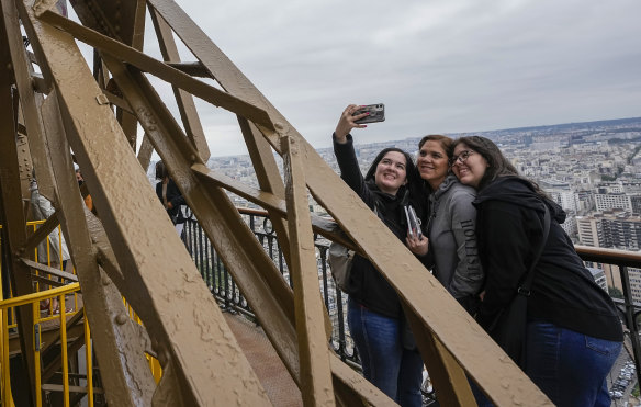 Visitors take a selfie with a phone from the Eiffel Tower.