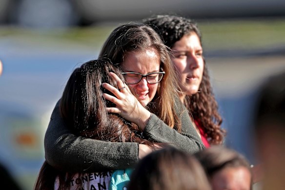Students released from a lockdown embrace following the shooting.