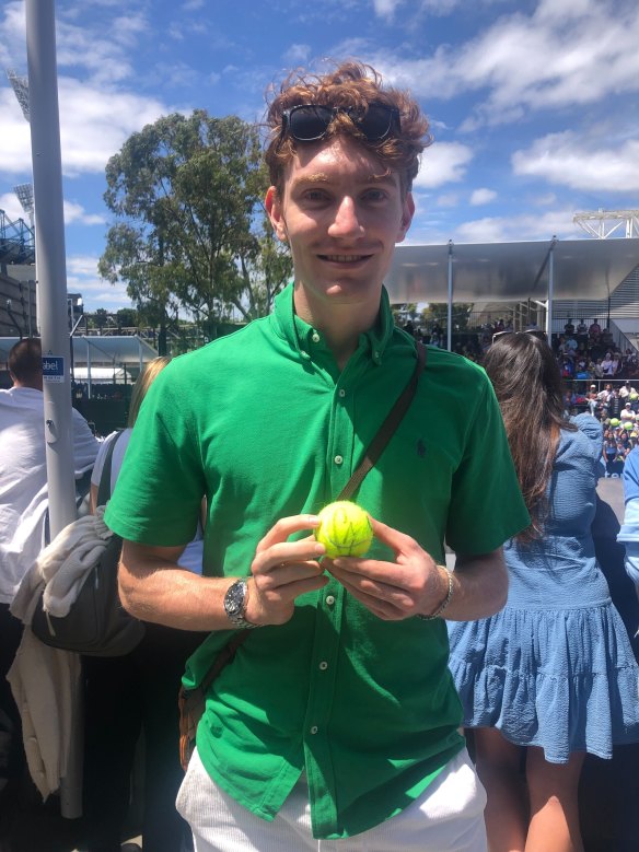 Wil Negline shows off a tennis ball signed by Carlos Alcaraz.