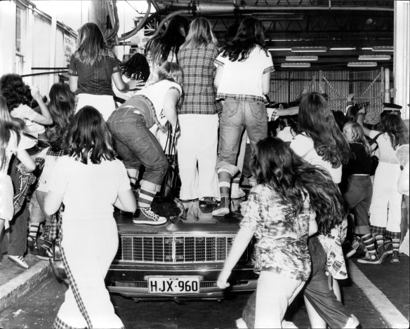 Fans climb a police car when the Bay City Rollers arrived at Sydney Airport in 1975.