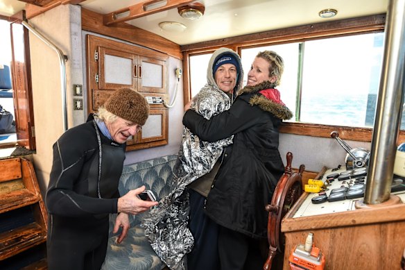 Swimmer Grant Siedle re-enacts the swim of Doug Mew across the rip from Point Lonsdale to Point Nepean on the same day 13th June just wearing speedos. Support team Eugene and girlfriend Kate celebrate and warm Grant up after the swim.