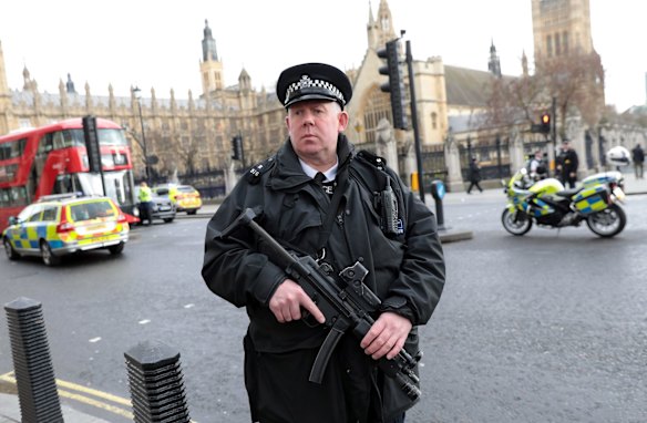 Armed officers attend to the scene outside Westminster Bridge.
