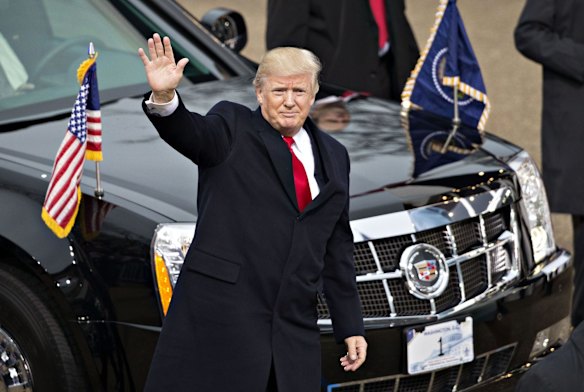 U.S. President Donald Trump waves while walking near the White House during the 58th presidential inauguration parade in Washington, D.C.
