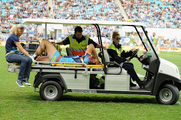 Nathan Davis of the Titans leaves the field injured.
