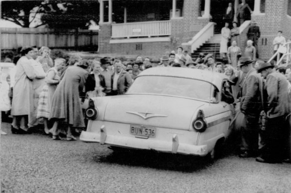 "Crowds gather outside Wyong court today to see Simmonds as he leaves in a car under police escort for Sydney." November 16, 1959. 