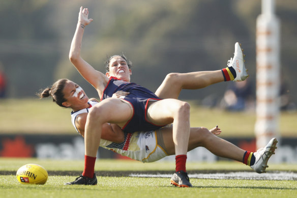 Adelaide's Angela Foley of the Crows brings down Demon Tegan Cunningham.