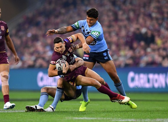 Billy Slater of the Maroons is tackled by Boyd Cordner (left) and Latrell Mitchell (right).