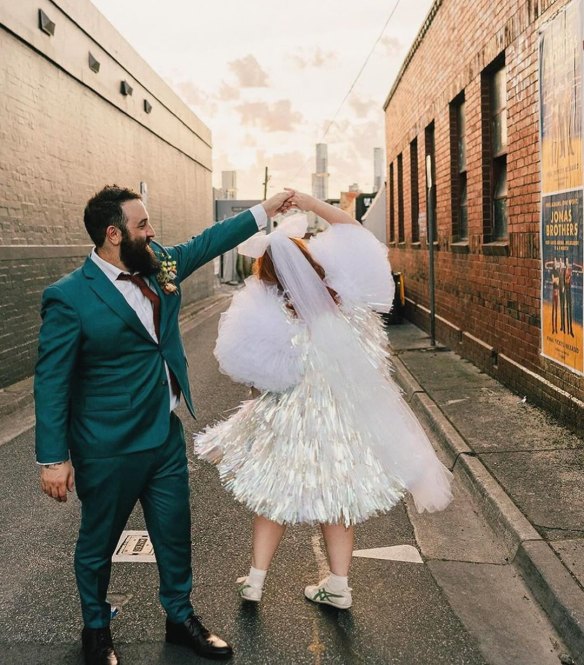 A bride wearing a “custom puff reception dress” by Rachel Burke on her wedding day.