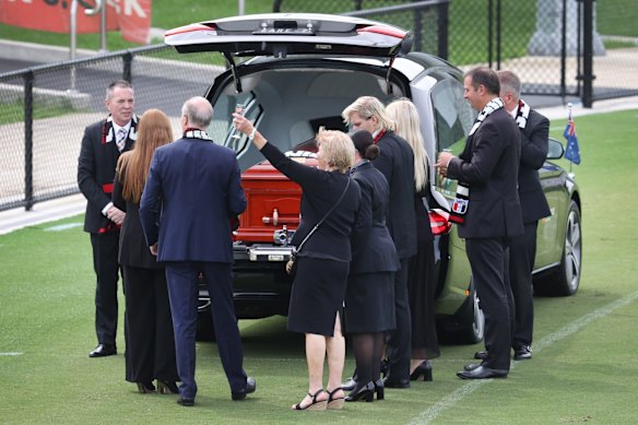 Shane Warne's mother Brigitte raises a glass to the mourners gathered at his private funeral at St Kilda Football Club. 

