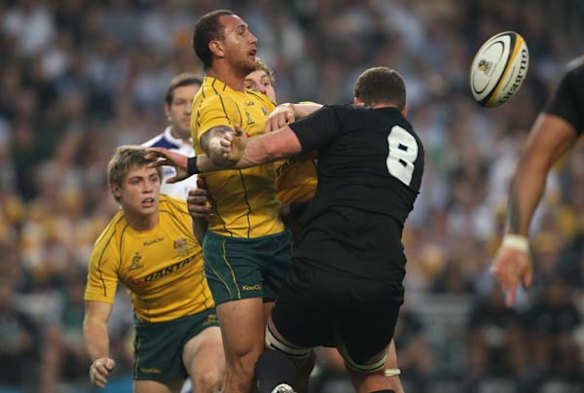 Quade offloads the ball in the tackle of Kieran Read.