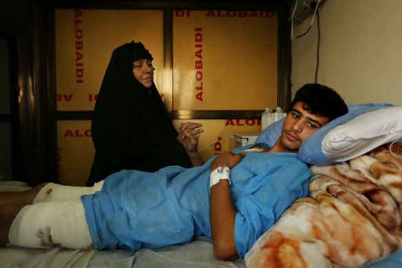 Iraq volunteer fighter, Ismail Abdul Hassan 17, holds his mother Farha Jury's hand as he recovers in hospital in Baghdad, from wounds caused by an IED explosion whilst fighting against ISIS.