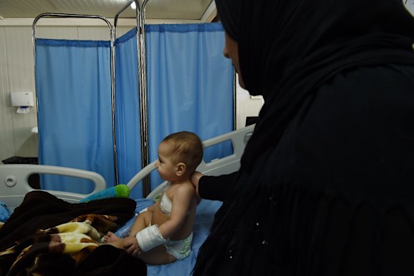 Qasid Radhwan 11 months old is comforted by his Aunty at the Athba Field Hospital, Athba, Iraq.
