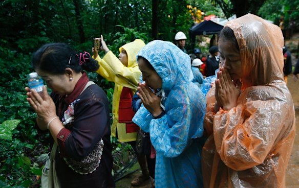 Relatives of 12 young soccer team members and their coach pray for their rescue.