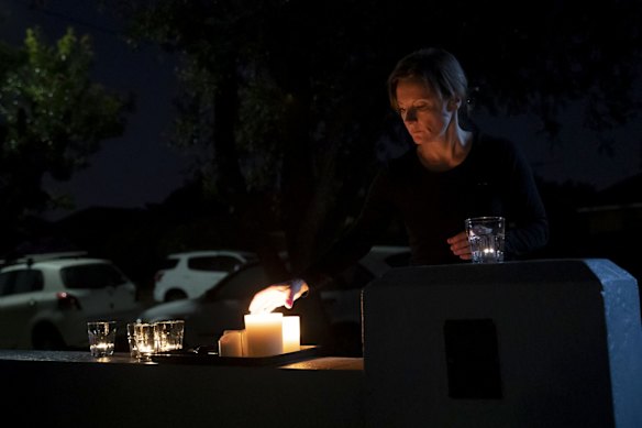 Emma Buzo lights a candle in preperation for a driveway dawn service for ANZAC Day.