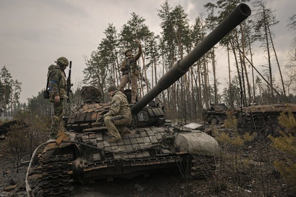 A Ukrainian serviceman takes a selfie photograph standing on a destroyed Russian tank after Ukrainian forces overran a Russian position outside Kyiv.