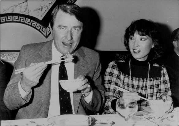 Watched by his interpreter Grace Chow, NSW Premier Neville Wran waves his chopsticks.