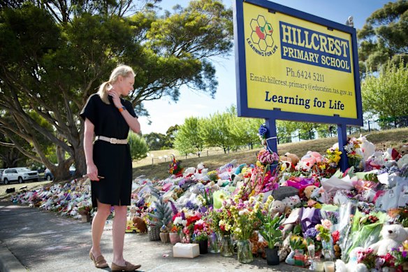 Tasmanian Minister Education, Hon Sarah Courtney MP, reads the tributes left outside Hillcrest Primary School.