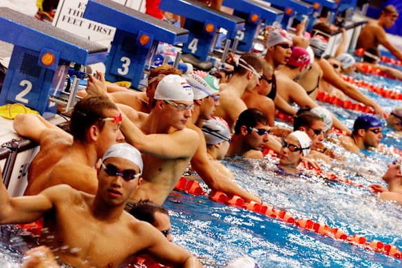 Olympic swimmers crowding all eight lanes during a morning training session two days out from the start of competition at the International Aquatic Centre. 