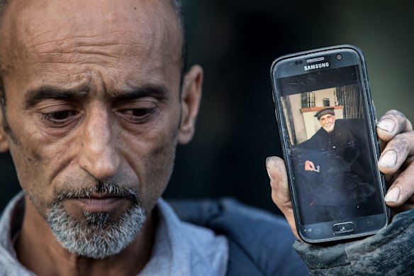 Omar Nabi holds a photo of his father, 71 year old Haji Daoud who was killed in the Masjid Al Noor Mosque in Christchurch.