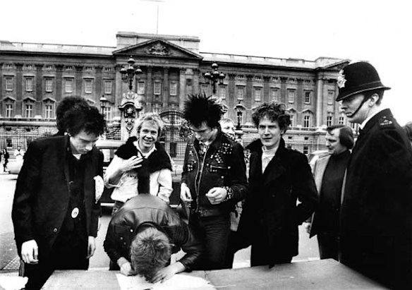 McLaren (right) and the Sex Pistols signing a recording contract outside Buckingham Palace.