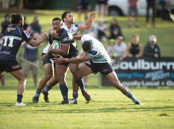 The Brumbies' Irae Simone is tackled by the Waratahs' Karmichael Hunt and Curtis Rona. 