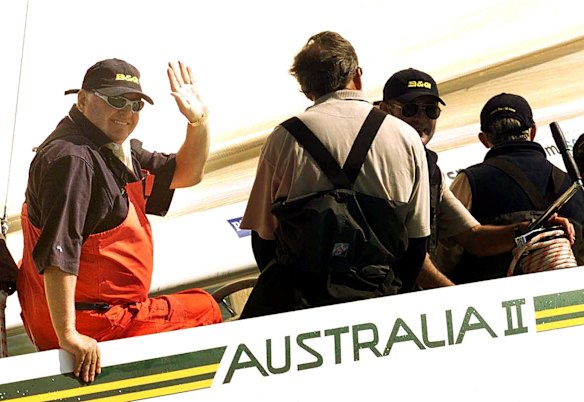Alan Bond waves from Australia II during a race around the Isle of Wight, England, for the America's Cup Jubilee, August 21, 2001.
