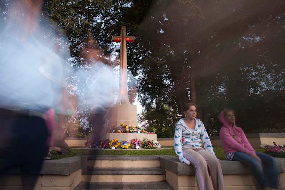 People gather around the cross of sacrifice after the Dawn Service at the Adelaide River War Cemetary 100 km south of Darwin.