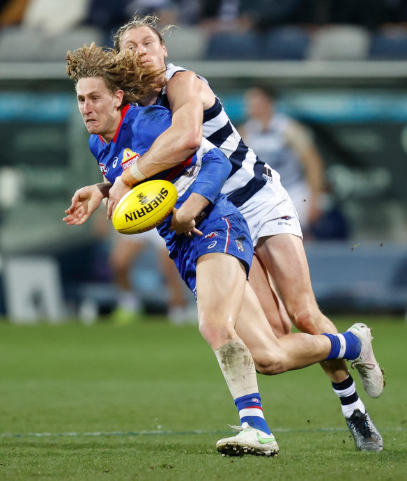 Aaron Naughton is tackled by Mark Blicavs.
