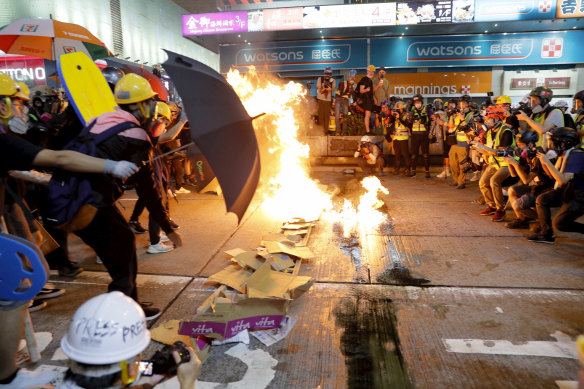 Protesters burn cardboard to form a barrier as they confront with police in Hong Kong.