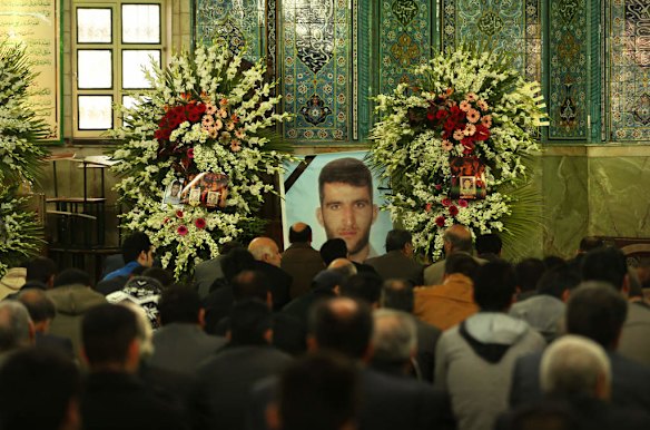 Men gather infront of a large photo of killed asylum seeker Reza Barati during the memorial service.