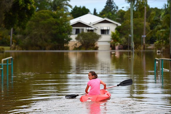 Maleah Jones 8yrs canoes up flooded Bright street to her home in Lismore. 