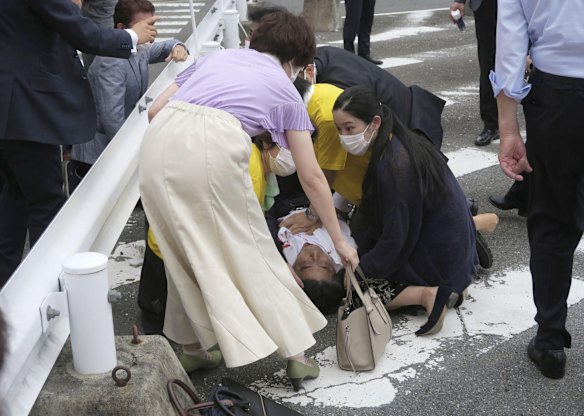 Japan's former Prime Minister Shinzo Abe, center, falls on the ground in Nara. According to reports, Abe was in heart failure after being shot during a campaign speech.