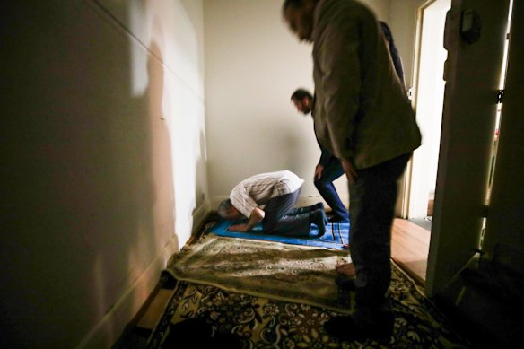 Uighur men during evening prayers in the prayer room of a Uighur restaurant - that used to be a church - in Adelaide.