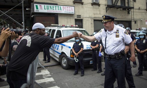 NYPD Deputy Police Chief McCarthy greets protesters as they take part in a solidarity march, Tuesday, in New York.