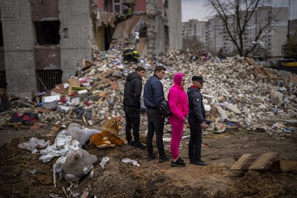 Residents look at their house destroyed by a Russian bomb in Chernihiv.