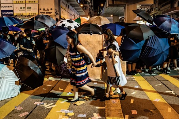 Pedestrians walk past a cross as protesters prepare to clash with police outside the Mongkok Police Station on September 6, 2019 in Hong Kong, China. 