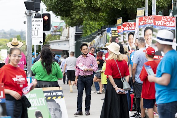 Strathfield Labor candidate Jason Yat-sen Li (centre) at the Croydon Park Public School polling booth.