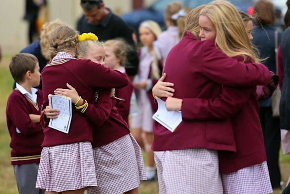 Friends from the school console each other after the service.