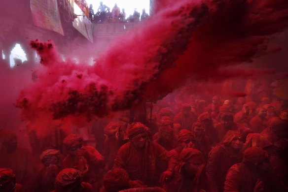 Coloured powder is thrown on Hindu men from the village of Nandgaon.