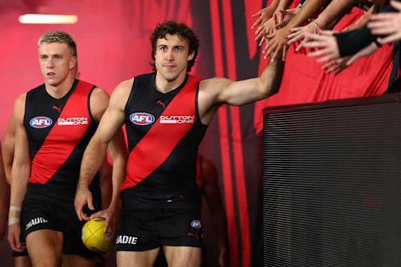 Hands up: Essendon skipper Andrew McGrath heads out to battle.