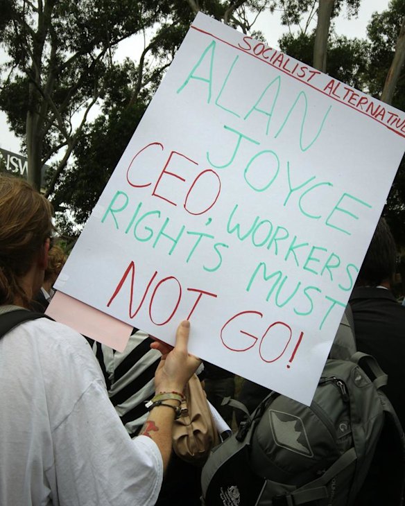 A protestor holds a sign stating "Alan Joyce CEO, workers rights must not go", outside the Qantas AGM at the Sir John Clancy Auditorium, University of NSW, Kensington, Sydney. 28th October, 2011. Photo by Kate Geraghty