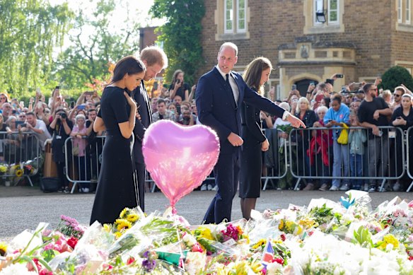 Meghan, Duchess of Sussex, Prince Harry, Duke of Sussex, Prince William, Prince of Wales and Catherine, Princess of Wales look at floral tributes laid by members of the public on the Long walk at Windsor Castle.